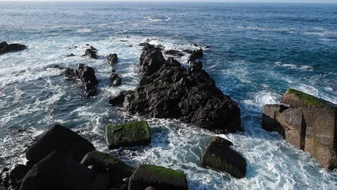 Big waves break on the rocky shore, white foam on the water. Stock Footage 129361818