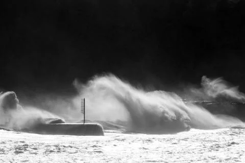 Big waves breaking on breakwater Stock Photos