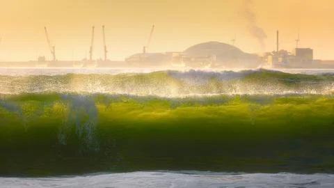 Big waves breaking on the shore at sunset Stock Photos