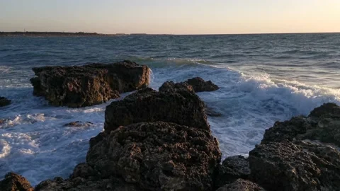 Big waves crash against the rocks. Storm at sea at sunset Stock Footage 145273153