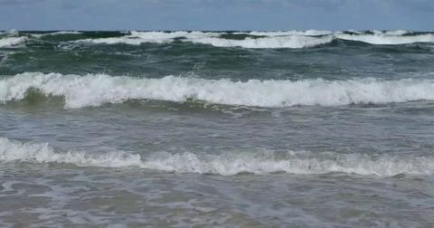 Big waves crash rolling over sand beach with lots of foam 4k sunny day Stock Footage 80053664