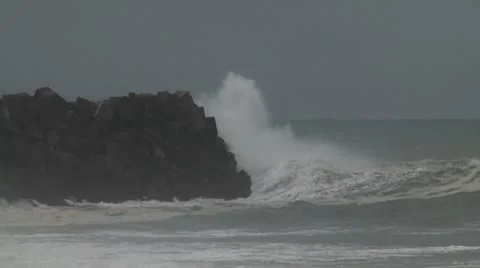 Big waves crash onto a sea wall Stock Footage 8963423