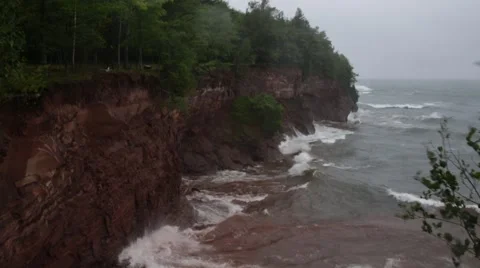 Big waves crashing into red cliffs Stock Footage 46060340