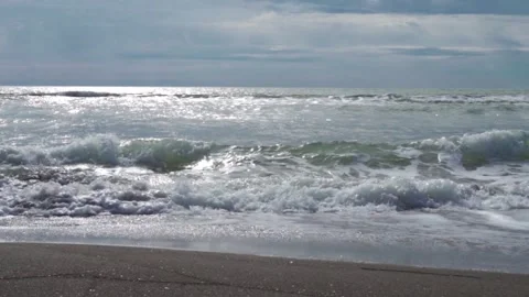 Big waves with foam on the sandy beach Stock Footage 241664709