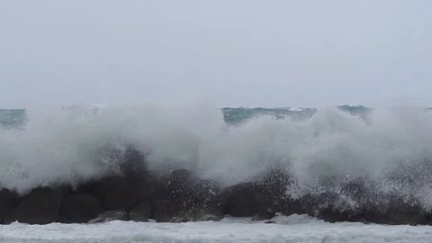 Big waves foaming over wavebreaker Stock Footage 190587864