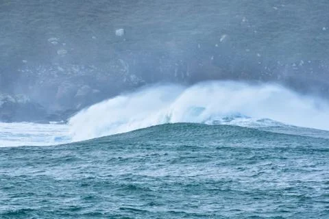 Big waves hit the rocks in rough seas. On a cloudy day. Galicia Spain. Stock Photos