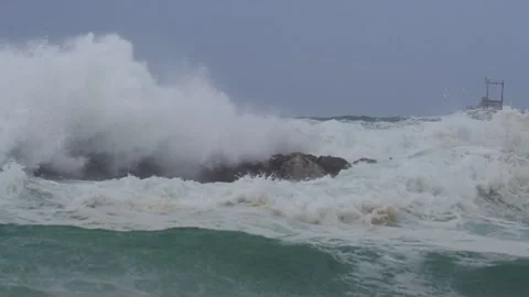 Big waves over wavebreaker, slow motion Stock Footage 186492075
