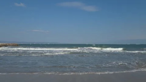 Big waves reaching the shore and leaving lots of foam Stock Footage 302297377