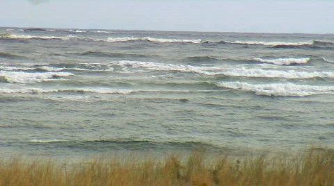 Big waves rolling towards a beach on a blustery day Stock Footage 759642