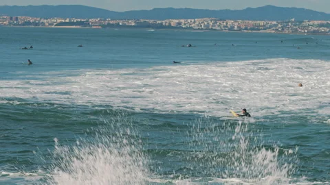 Big waves splash while people surfing in the Atlantic Ocean on a sunny day. Stock Footage 130628195
