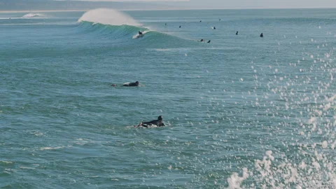 Big waves splash while people surfing in the Atlantic Ocean on a sunny day. Stock Footage 130628325
