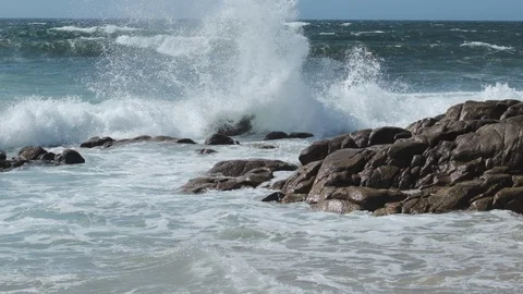 Big waves splashes in slow motion against rocks on the beach Vídeos de archivo 115785095