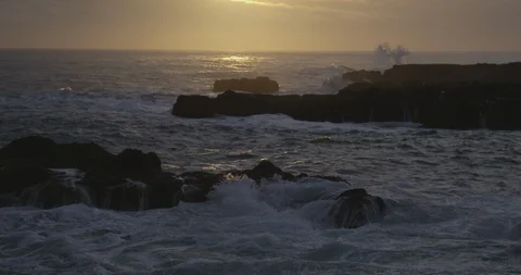 Big waves splashing against the rocks in the sea at sunset Stock Footage 103807168