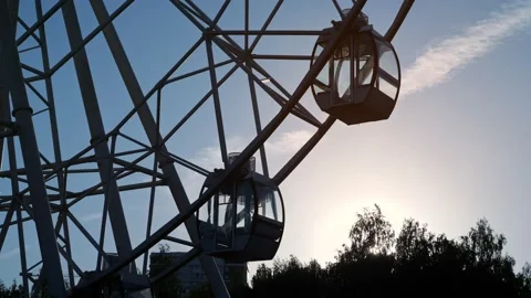 Big wheel ride with empty cabins rotates in local park Stock Footage 154997367