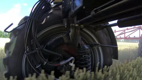 Big wheel is spinning on a self propelled sprayer while driving across the field Stock Footage 138138803