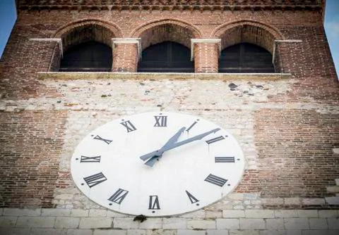Big white clock on the facade of the bell tower Stock Photos