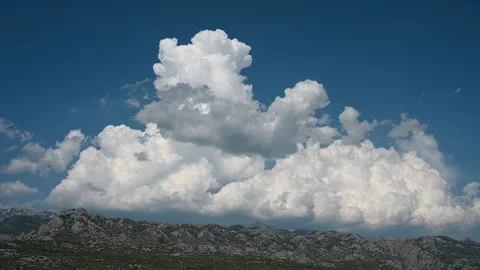 A big white cloud on the horizon. A cloud over the mountain. Stock Footage 253755055