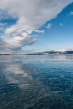 A big white cloud reflected in the transparent ice of Baikal Foto stock