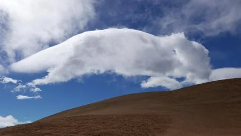 Big white cloud rolling like dog on brown vulcanic surface of Pico del Teide  Stock Photos