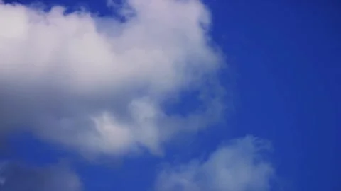 Big white clouds expand across a clear blue sky Stock Footage 329756722