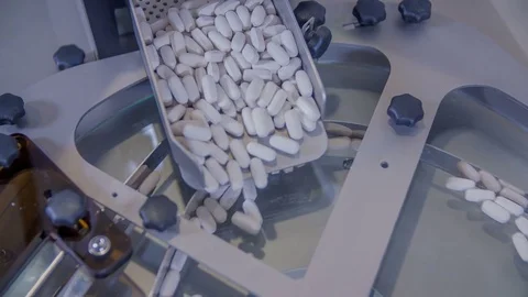 Big white pills are falling down on a conveyor belt Stock Footage 71525762