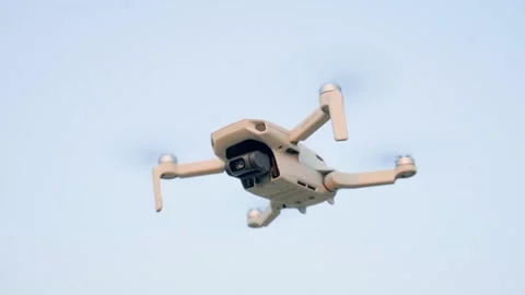 Big white quadcopter with a camera, hover in the air. high angle view. Video stock 228684823