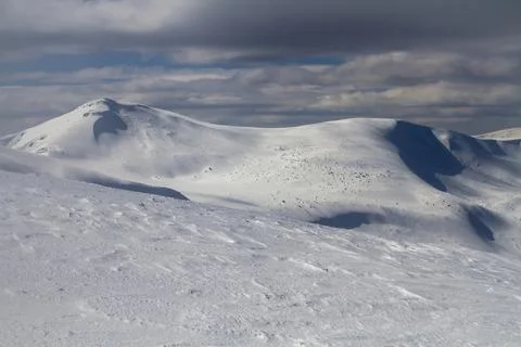 Big white snow fields and blown snow in high mountains Stock Photos