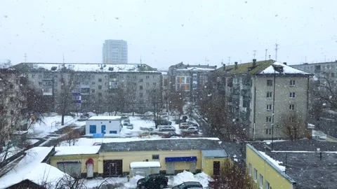 The big white snowflakes are falling and spinning in a snowy city Stock Footage 173440295