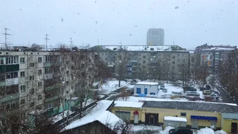The big white snowflakes are falling slow and spinning in a snowy city Stock Footage 178548035
