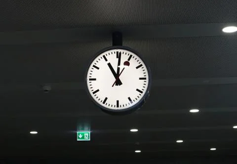 A big white wall clock at train station Stock Photos
