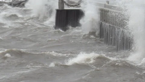Big wild waves breaking crashing into shore in wind storm Vídeos de archivo 147978843