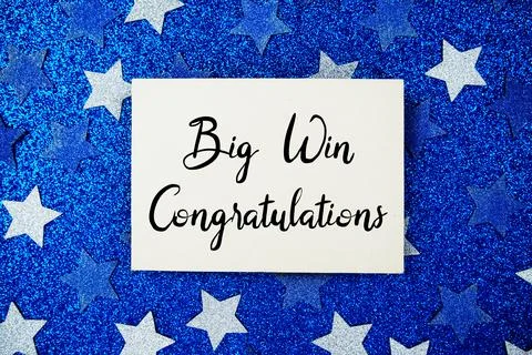 Big Win Congratulations text written on paper card with star glitter on blu.. Stock Photos