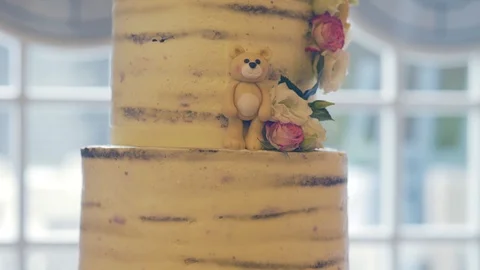 Big yellow cake with bear and flowers in restaurant hall Vídeo Stock 88042369
