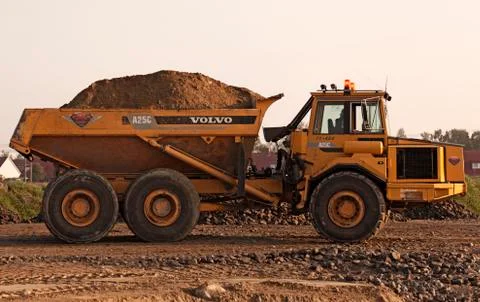 Big yellow work machine transporting soil for road work Stock Photos