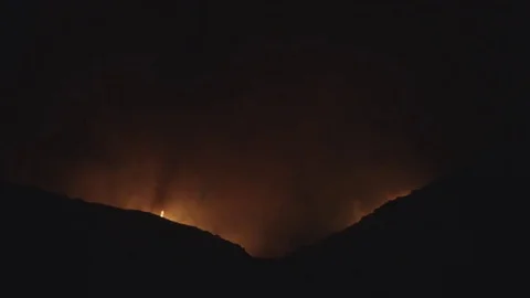 Bigger flames appearing over ridgeline Stock Footage 79604565