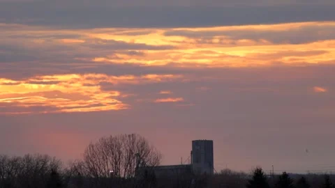Bight Orange Clouds over Grain Elevator Stock Footage 131705033