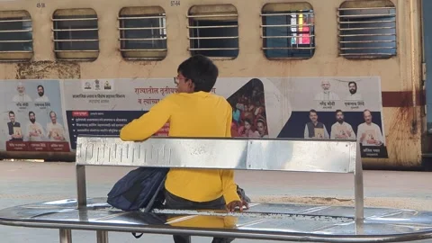 Bihar, India- 2024, Oct 16; Boy Sitting on Bench at Railway Platform with Train  Vidéo 304116154