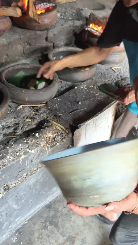 Bika Baker Pouring Batter into Clay Molds Before Traditional Wood-Fired Baking Stock Footage 339793886