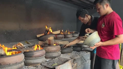 Bika Baker Pouring Batter into Clay Molds Before Traditional Wood-Fired Baking Stock Footage 339795225