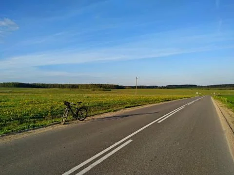 Bike on the side of an empty road Stock Photos