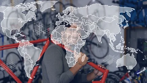 Bike tech lifting red frame, shouldering, inspecting for repair while world map Stock Footage 332685730