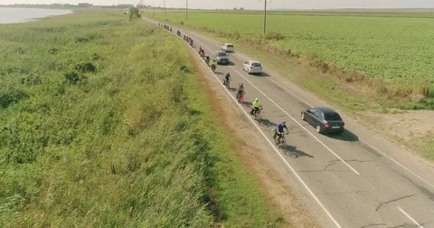 Bike trip on the road between the fields, top view. A bicycle column rides by Video stock 78937715
