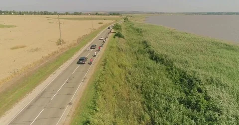 Bike trip on the road between the fields, top view. A bicycle column rides by Video stock 78937989