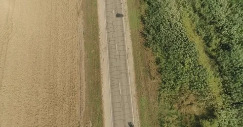 Bike trip on the road between the fields, top view. A bicycle column rides by Video stock 78938203