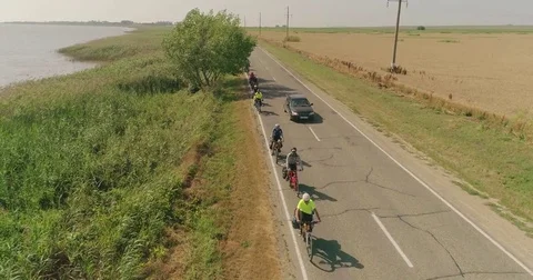 Bike trip on the road between the fields, top view. A bicycle column rides by Video stock 78941186