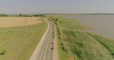 Bike trip on the road between the fields, top view. A bicycle column rides by Video stock 78941420