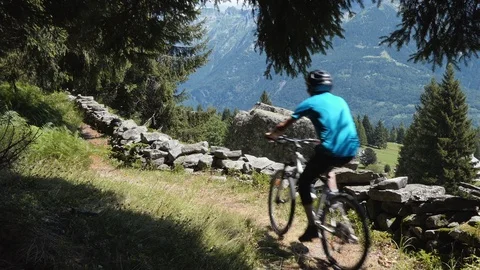 Biker on alpine trail with rocks Stock Footage 114175242