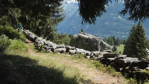 Biker on alpine trail with rocks Stock Footage 114175328