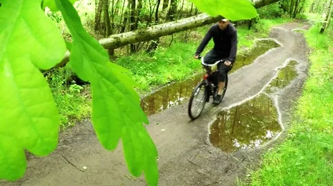Biker on bicycle riding on muddy forest track. 스톡 동영상 63405295