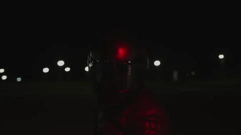 Biker in black leather jacket and black helmet sits behind wheel of his Vidéo 293502228